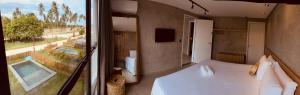 a bedroom with a bed and a view of a pool at Housi, condo beira mar em Milagres in Passo de Camarajibe