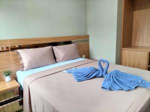 a bed with two towels on top of it at Cozy Residence Tomang in Jakarta