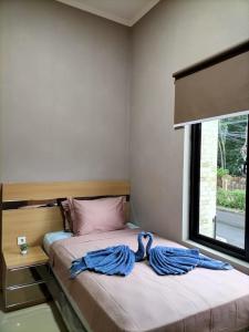 a bedroom with two beds and a window at Cozy Residence Tomang in Jakarta