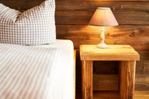 ein Bett und einen Tisch mit einer Lampe auf einem Beistelltisch in der Unterkunft Haus am Bach - gemütliche Frühstückspension in Allershausen