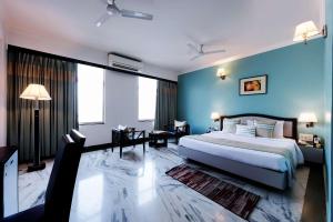 1 dormitorio con 1 cama grande y paredes azules en Capitol Residency, en Ranchi