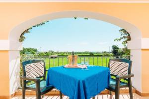 a table with a blue table cloth and two chairs at Sentido Orosei Beach in Orosei