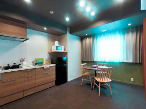 een keuken met een tafel en stoelen in een kamer bij Hotel S-Presso West in Osaka