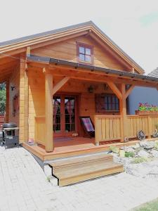 une cabane en rondins avec une terrasse couverte et un grill dans l'établissement Chata Kaprík, à Liptovský Mikuláš