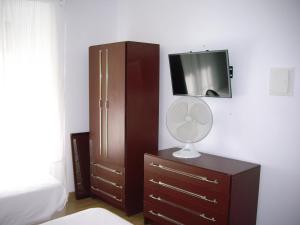 a bedroom with a dresser and a tv on a wall at Residencial Camoes in Lisbon