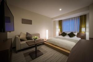 a hotel room with a bed and a couch at Hotel Royal Morioka in Morioka