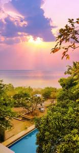 ムンバイにあるEKO STAY- Tropical Villasの海の景色を望むスイミングプールの景色を望めます。