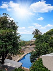EKO STAY- Tropical Villas في مومباي: اطلالة على المسبح والمحيط