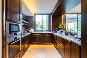 a kitchen with wooden cabinets and a large window at Z Villa Tam Đảo - Venuestay in Vĩnh Phúc