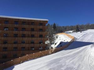 弗利姆斯Ferienwohnung 3,5 Zimmer direkt an Ski- und Bikepiste的一座建筑物旁边有雪盖的斜坡