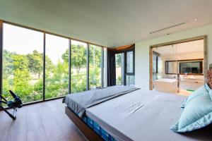 a bedroom with a large bed and large windows at Z Villa Tam Đảo - Venuestay in Vĩnh Phúc +62 photos
