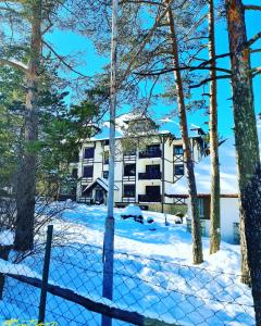 a building in the snow with a fence at Matija LUX Konaci in Zlatibor