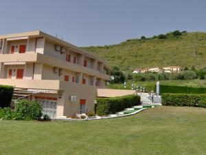 a building with a grass yard in front of it at Hotel Svizzero in Sangineto