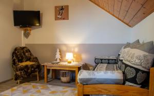 a living room with a bed and a table and a chair at Les Garianes in Saint-Léger-les-Mélèzes