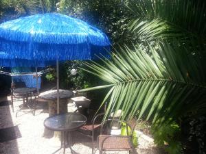 a group of tables and chairs with a blue umbrella at Camere Da Aldo in centro Sirolo in Sirolo