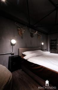 a bedroom with a bed with antlers on the wall at 生活就是Lifeis民宿新城館-寵物KTV包棟 in Kangle