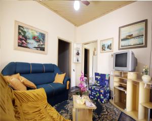 un salon avec un canapé bleu et une télévision dans l'établissement Casa Pagotto, à Olímpia