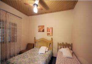 1 dormitorio con 2 camas y ventilador de techo en Casa Pagotto, en Olímpia