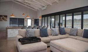 a living room with a large couch and a bar at Elements Sunrise Bush Lodge in Bela-Bela