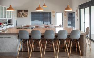 a kitchen with a large kitchen island with stools at Elements Sunrise Bush Lodge in Bela-Bela