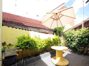 - une table avec un parasol sur la terrasse dans l'établissement Casa Pagotto, à Olímpia