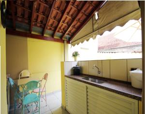 une cuisine avec deux chaises et un évier dans l'établissement Casa Pagotto, à Olímpia