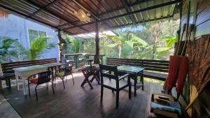 a screened in porch with tables and chairs and a window at Aonang Third Place Hometel in Ao Nang Beach