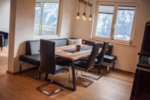 a dining room table with chairs and a couch at Alpenblick de Luxe in Oetz