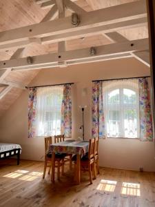 a dining room with a table and two windows at Czarna Jachta - Na szlaku legend - - - - - Pokoje nad jeziorem in Kruklanki