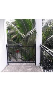 a black gate with a palm tree behind it at Sunrise Sensation holiday home. in Centre de Flacq
