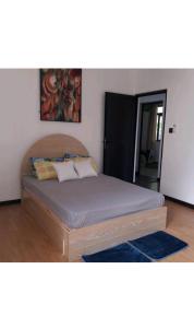 a bedroom with a large bed with a wooden headboard at Sunrise Sensation holiday home. in Centre de Flacq