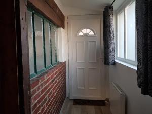 LE CHÈVREFEUILLE في بونت سانت ماكسانس: باب أبيض في غرفة بجدار من الطوب