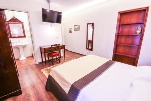 Schlafzimmer mit einem Bett, einem Schreibtisch und einem Waschbecken in der Unterkunft 96 Guest House in Reggio di Calabria