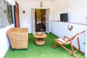 a room with a chair and a table and a television at 96 Guest House in Reggio di Calabria