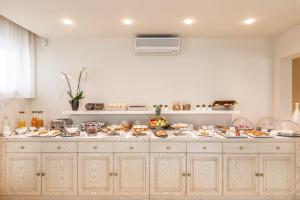 una cucina con molto cibo su un bancone di Hotel & Residence Exclusive a Marina di Carrara