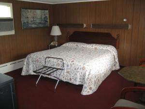 a bedroom with a bed and a table and a lamp at Fountain View Motel in Richfield Springs