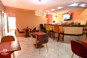 ein Restaurant mit einer Bar und einer Person, die an einem Tresen sitzt in der Unterkunft Hotel Astoria in Douala