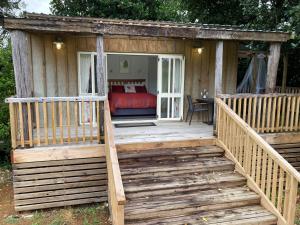 a wooden cabin with a bed on a deck at The Treehut in Ohauiti