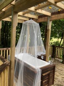 a wooden pergola with a bed with a net at The Treehut in Ohauiti +2 photos