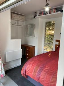 a bedroom with a bed and a desk and a window at The Treehut in Ohauiti