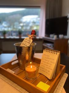 einen Tisch mit einer Kerze, einer Tasse und einem Notizbuch in der Unterkunft Kleine Auszeit Winterberg in Winterberg