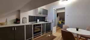 a kitchen with gray cabinets and a table and a dining room at Central Palace Iași Apart in Iaşi