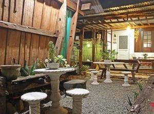 un patio con mesa, sillas y banco en RedDoorz Hostel @ Deomar Hometel & Farm Cafe Ilocos Sur, en Bantaoay