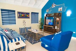 a blue living room with a couch and a tv at Villas the Palms Richmond in Richmond