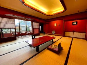 a living room with red walls and a table at Kyotoya in Takeo