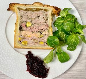 une plaque blanche avec un sandwich et des greens dessus dans l'établissement Villa de la Croix, à Villechétif