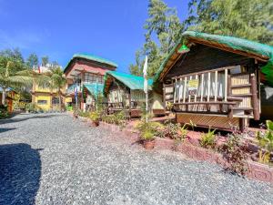 a group of wooden buildings with plants on a street at LaZerena Lodge in Zambales