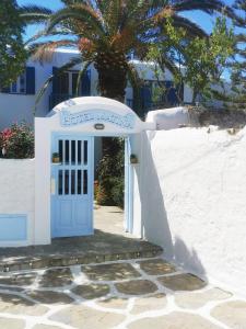 eine blaue Tür in einem weißen Gebäude mit einer Palme in der Unterkunft Matina Hotel in Mykonos Stadt