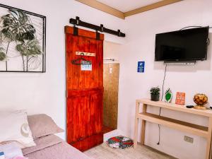 a room with a wooden door and a bed at LaZerena Lodge in Zambales