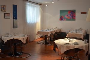 a row of tables in a restaurant with white table cloth at Hotel Adria in Mestre